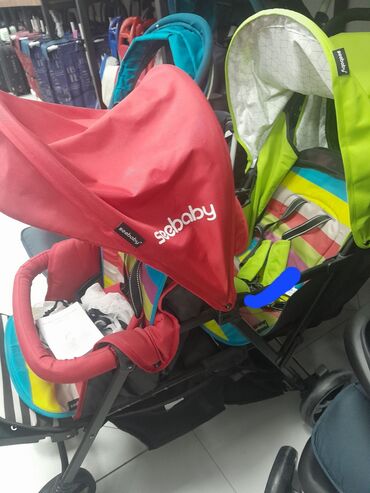 patike sa oznakom n: Dečja dupla kolica marke "Seebaby" u crvenoj i zelenoj boji. Kolica su