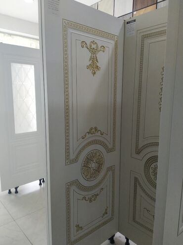 mdf qapilar: Ağ rəngdə qapı paneli, qızılı rəngli klassik naxışlarla bəzədilmişdir