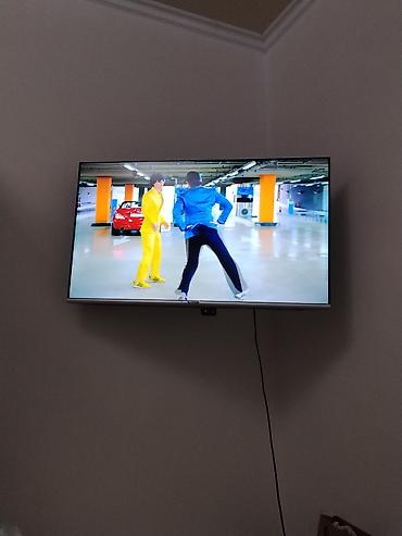 Телевизор с тонкими рамками, диагональ ориентировочно 43–50". Плоская