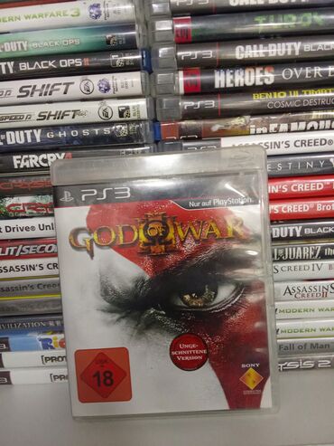 PS3 (Sony PlayStation 3): PlayStation 3 üçün "God of War" oyun diski. Bu, döyüş və macəra