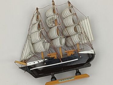Model żaglowca Belem z czarnym kadłubem i białymi żaglami. Stoi na