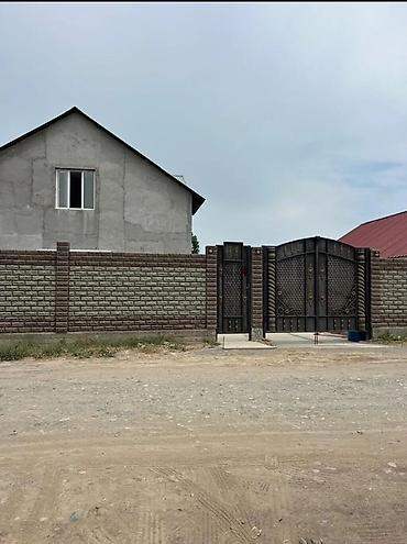 Продаётся частный дом с высоким кирпичным забором и коваными воротами