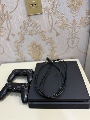 ps4 dualshock: Qara rəngli PlayStation 4 oyun konsolu və iki ədəd qara rəngli