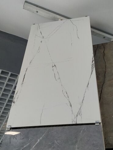 Elektrik malları: Ağ rəngli, mərmər naxışlı keramik plitə. Bu plitə, ağ rəngli fon