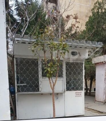 Ağ rəngli, metal konstruksiyalı mühafizə köşkü. Köşkün hər tərəfində