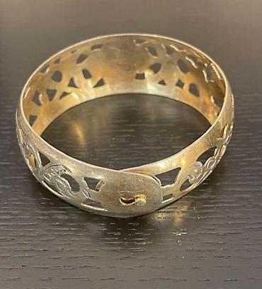 Серебряные браслеты: Серебряный браслет с позолотой с ажурным орнаментом. В центре браслета — 11
