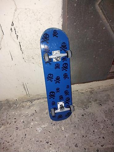 rulman: Skateboard – mavi rəngli lövhə, üst səthində qara kəllə-sümüklər — 1