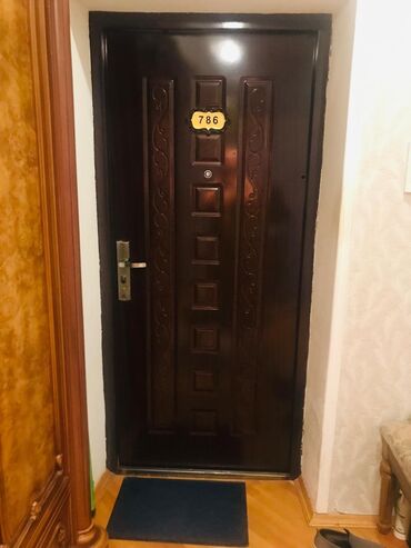 Elektrik malları: Tünd qəhvəyi rəngdə möhkəm mənzil qapısı. Qapının mərkəzində