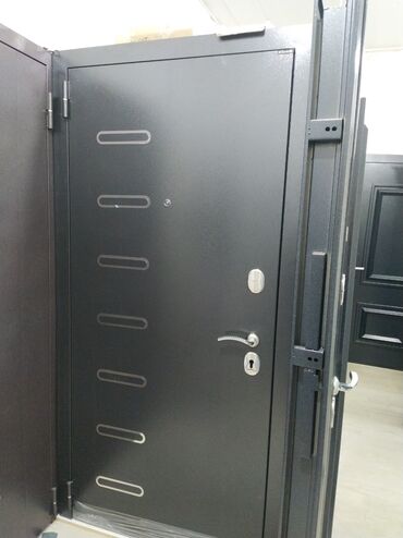 qapılar: Qara rəngdə, müasir dizaynlı metal qapı. Üzərində şaquli düzülmüş