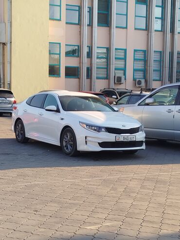 авто рассрочку без банка: Белый седан Kia Optima с динамичным дизайном кузова и черной решеткой