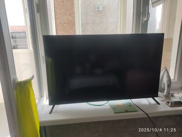усилитель mcintosh: LED-телевизор на ножках, диагональ примерно 43–50". Тонкие рамки