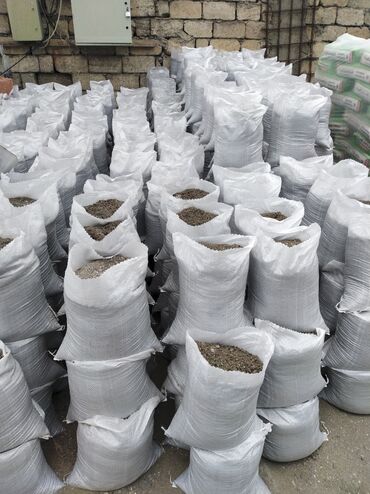 bitki: Ağ rəngli toxunma materialdan hazırlanmış çuvallar, içərisində çınqıl