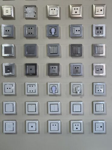 divar üçün kafel: Divarda müxtəlif növ elektrik açarları və rozetkalarından ibarət geniş