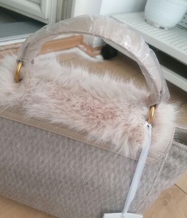 Torbe: Ženska torba sa preklopom od veštačkog krzna u bež boji. Torba ima dve — 8