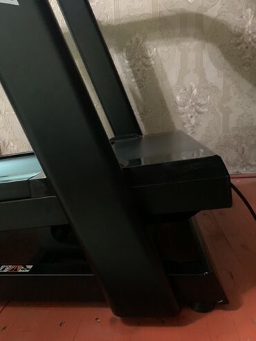 купить тренажер для ягодиц и бедер: Электрическая беговая дорожка черного цвета с надписью "GRAVITY" на