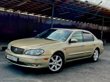 Nissan: Автомобиль Nissan Maxima в золотистом цвете. Седан с люком на крыше и