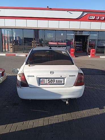 e6 3: Mazda Familia седан, белый цвет. Компактный городской автомобиль с — 3