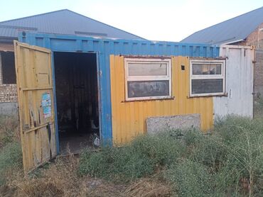 раздольное село: Металлический контейнер сине-желтого цвета с двумя окнами и дверью