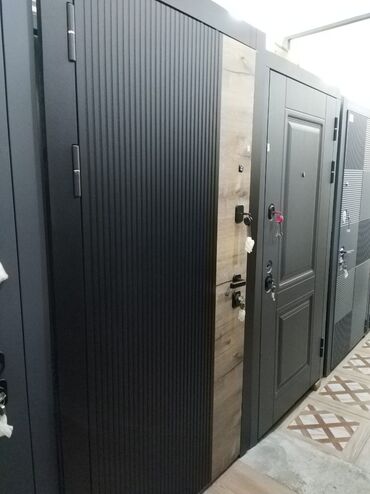 qapi alan: Qara rəngdə, şaquli xətlərlə dizayn edilmiş müasir metal giriş qapısı