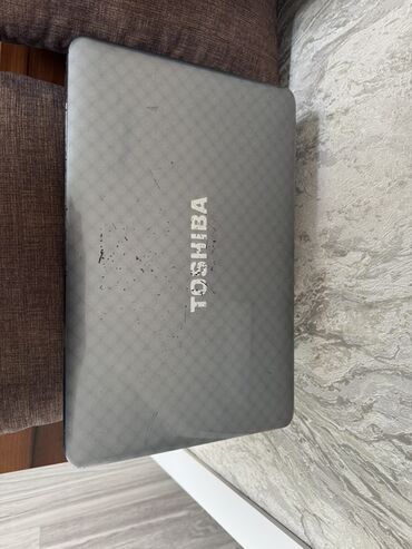 en ucuz notebook: Toshiba markalı boz rəngli noutbuk. Cihazın üst qapağında Toshiba