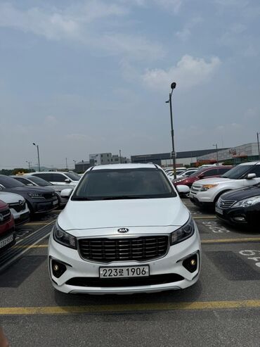 Kia: Белый минивэн Kia Carnival. Автомобиль с просторным салоном и