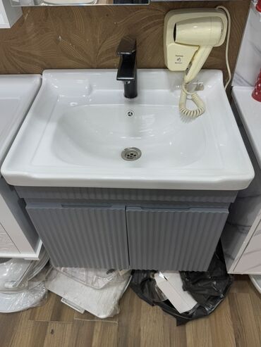 Moydadırlar: Ağ rəngli keramika lavabo və boz rəngli ikiqapılı şkafdan ibarət hamam