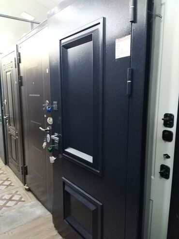 şeyf qapi: Qara rəngdə, müasir dizaynlı metal giriş qapısı. Qapıda kiçik nəzarət
