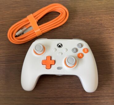 oyun konsolu ucuz: Ağ rəngdə, narıncı detalları olan Xbox oyun konsolu üçün nəzərdə