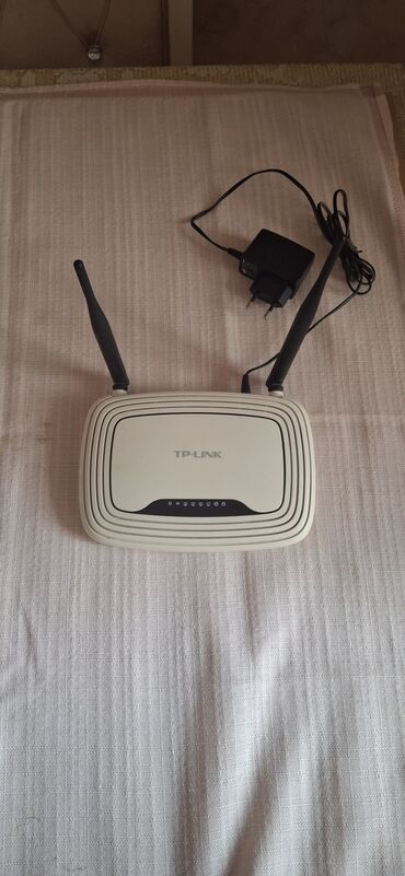 Мониторы: TP-Link brendinə məxsus iki antenalı router. Ağ rəngli, yığcam dizaynı