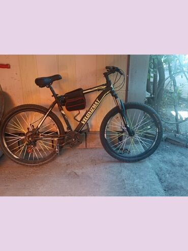 бюджетный горный велосипед: Горный велосипед черного цвета от VELOXIZMAT, оснащенный сумкой для