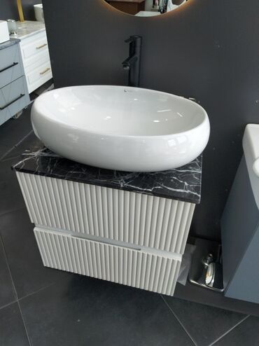 Hamam üçün aksessuarlar: Ağ rəngli oval formalı keramika lavabo, qara mərmər effektli tezgahın