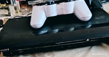 PS3 (Sony PlayStation 3): Qara rəngli Sony PlayStation 3 oyun konsolu və ağ rəngli idarəetmə