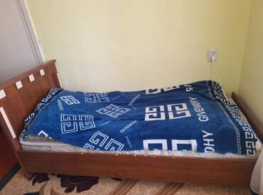 кровать кожаная: Деревянная кровать с прямоугольным изголовьем. Матрас покрыт синим