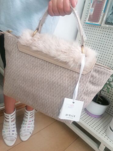 Torbe: Ženska torba sa preklopom od veštačkog krzna u bež boji. Torba ima dve — 4