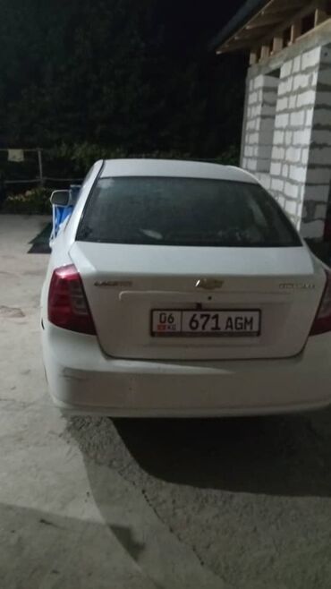 купить машину до 5000 долларов: Седан Chevrolet Lacetti белого цвета. Модель "Lacetti" и эмблема