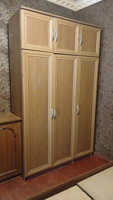 Üç qapılı, yuxarı hissəsi əlavə dolab bölmələri ilə olan geyim şkafı