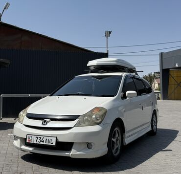 кофр на крышу автомобиля: Белый минивэн Honda Stream с установленным на крыше грузовым боксом