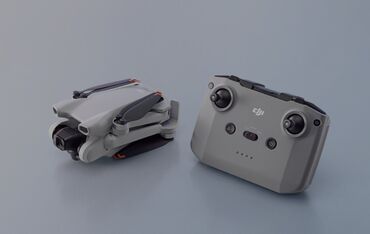 дрон dji mini 3: Компактный квадрокоптер DJI серого цвета. В сложенном виде занимает