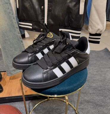 Krasofkalar və idman ayaqqabıları: Qara rəngdə olan, yan tərəflərində ağ zolaqları olan Adidas Campus