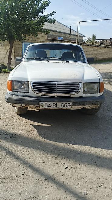 2 qapılı maşın: Ağ rəngli GAZ 3110 sedan avtomobil. Klassik kuzov quruluşuna malik 4 — 1