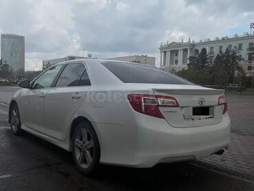 Toyota: Toyota Camry белого цвета, с задним спойлером и легкосплавными