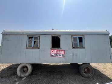 купить кирпичный гараж: Передвижной вагончик серого цвета на колесах, подходящий для
