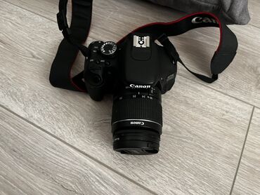 компактные фотоаппараты: Цифровая зеркальная камера Canon, оснащенная объективом. Камера