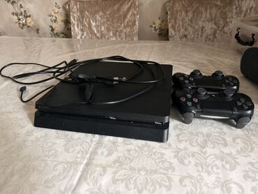playstation oyunları: Qara rəngli Sony PlayStation 4 oyun konsolu. Komplektə iki ədəd