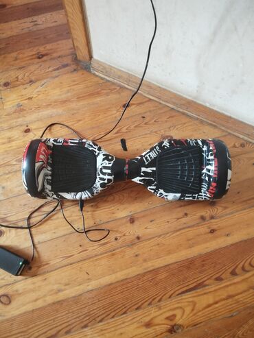Ağ, qara və qırmızı rənglərdə qrafiti dizaynlı hoverboard. Şəhər