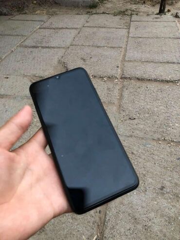комбайн сатылат: Смартфон с черным корпусом, оснащенный фронтальной камерой в