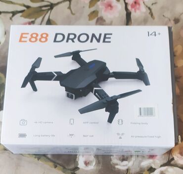 Stəkanlar: E88 dronu qara rəngdə, qatlana bilən dizaynı və dörd pərvanəsi ilə