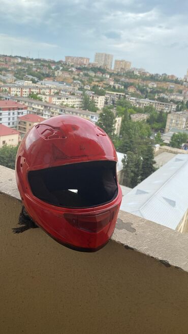 Moto dəbilqələr: Qırmızı rəngdə, tam üzü örtən motosiklet dəbilqəsi. Aerodinamik
