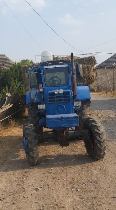 işlənmiş traktor: Mavi rəngdə kənd təsərrüfatı işləri üçün nəzərdə tutulmuş traktor. Bu