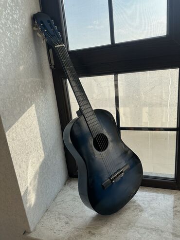 Musiqi alətləri üçün ləvazimatlar: Mavi rəngli klassik gitara. Alət altı simlə təchiz olunub və səs